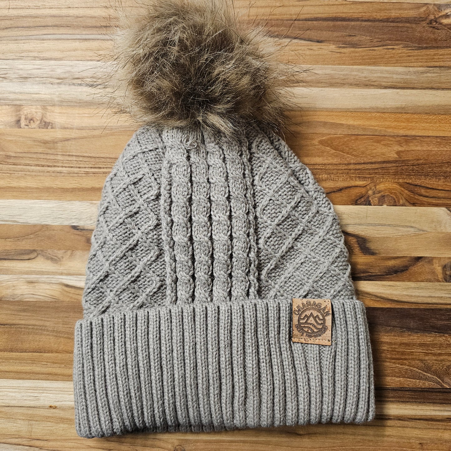 Okanagan Wave Cable Knit Toque in Oatmeal with Faux Fur Pom and Cork Patch