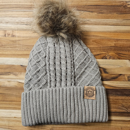 Okanagan Wave Cable Knit Toque in Oatmeal with Faux Fur Pom and Cork Patch